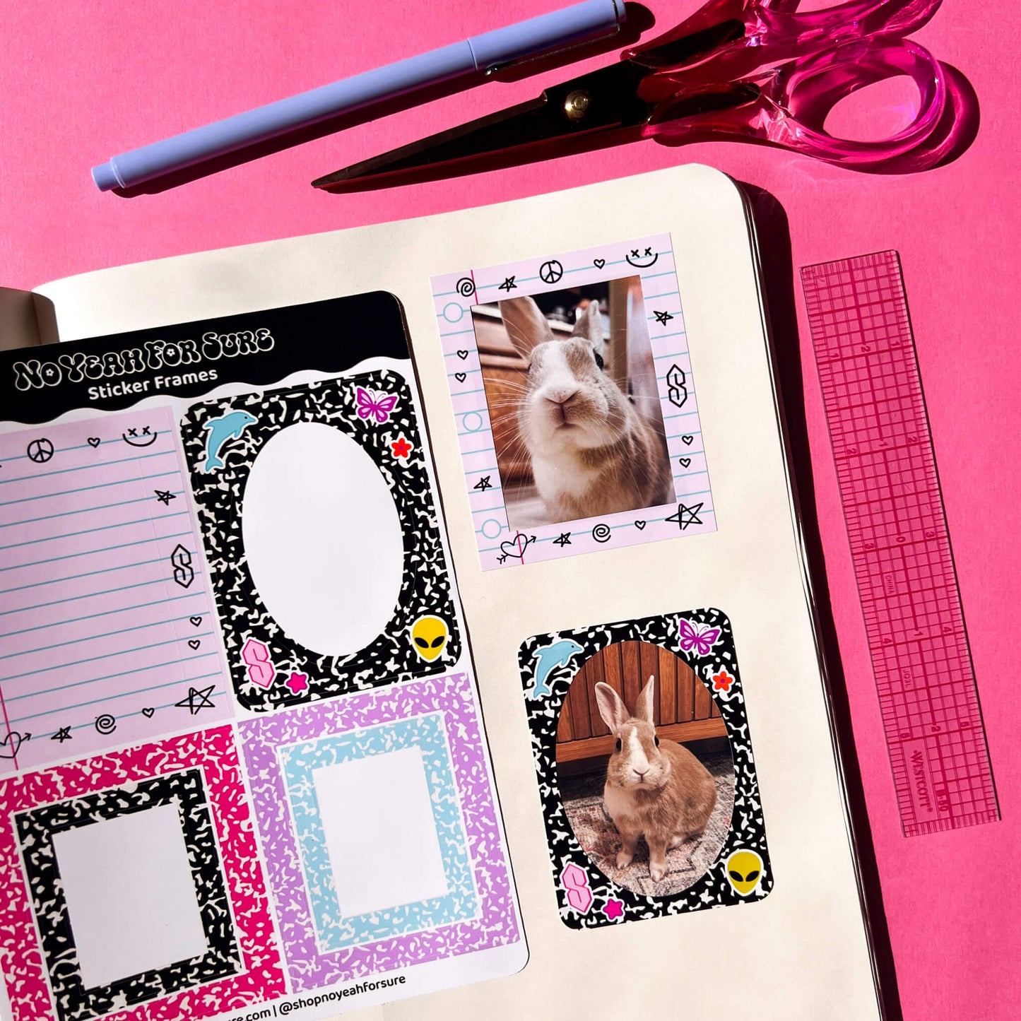 A styled flat-lay of a sticker frame sheet set in an open notebook on a bright pink background, with a pen, scissors, and ruler nearby. The sticker frames feature composition book patterns and nostalgic doodles.