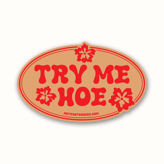 Oval-shaped sign with red text 'TRY ME HOE' on a beige background