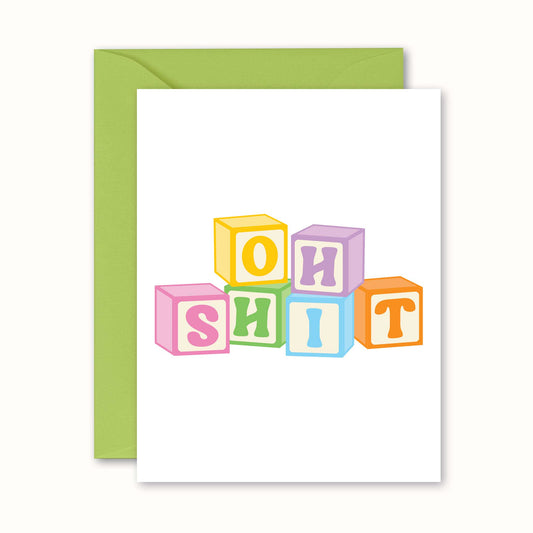 Greeting card with colorful block letters spelling 'OH SHIT' on a white background with a green envelope.