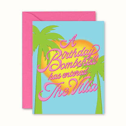 Birthday card with palm trees and 'A Birthday Bombshell has entered The Villa' text, pink envelope.