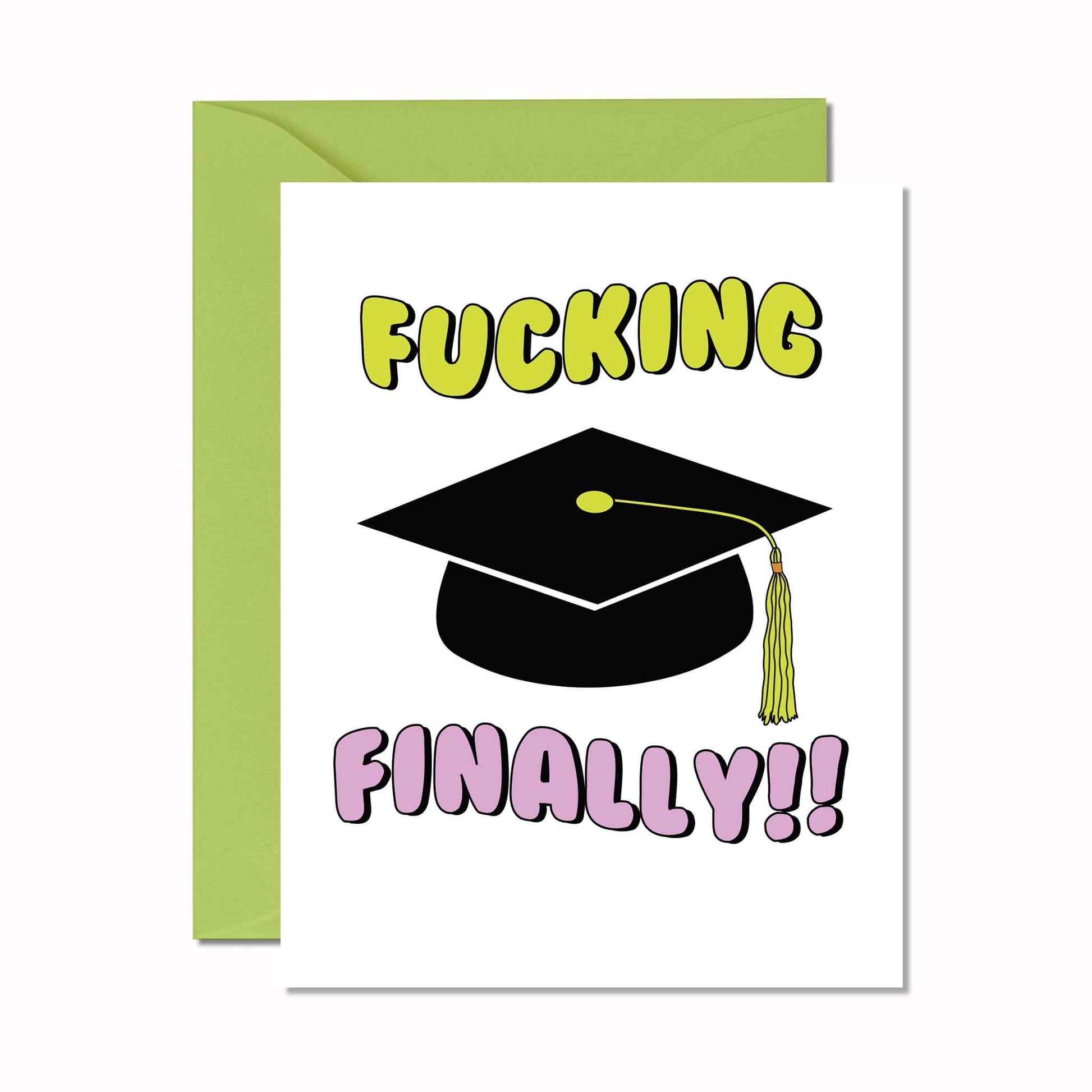 A greeting card with the phrase 'FUCKING FINALLY!!' printed in large green and lilac letters, above a graduation cap illustration. The card has a green envelope.