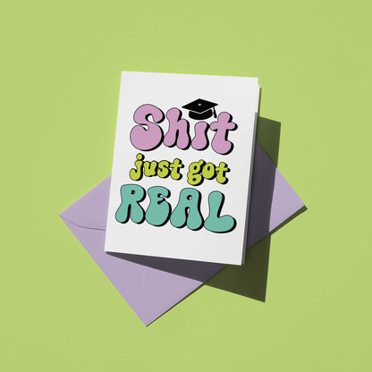 Card with 'Shit just got REAL' text and a graduation cap on a green background