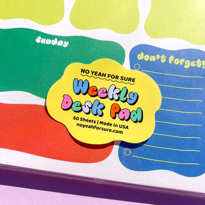 Weekly desk pad with colorful design and text on a white background