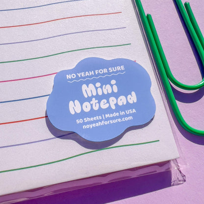 Mini notepad with colorful lines and a blue label on a purple background