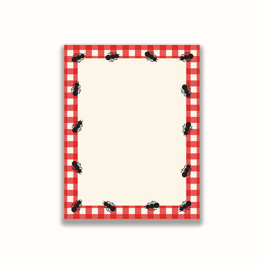 Notepad with red and white checkered border and ants design on a white background