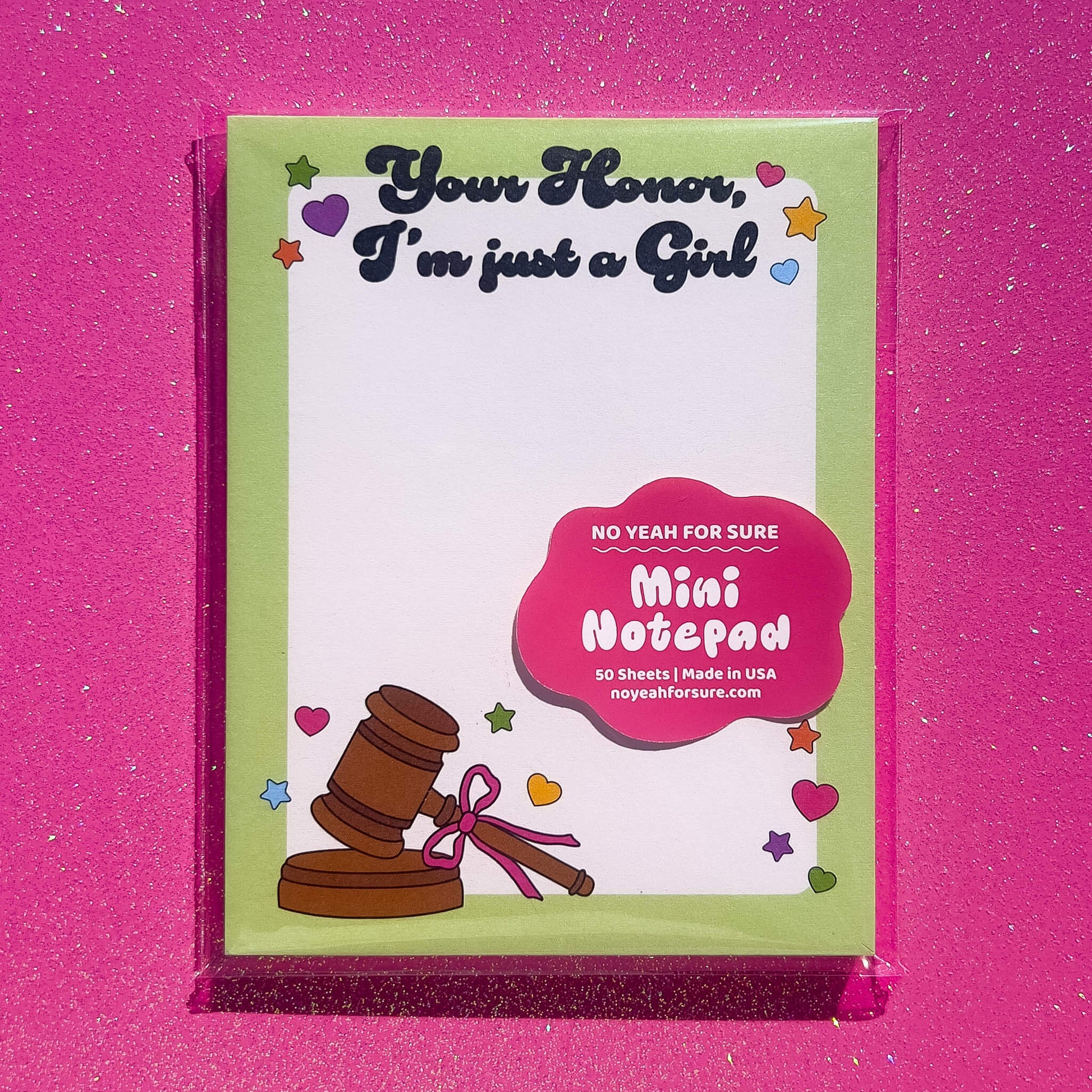 Mini notepad with a gavel illustration on a pink background