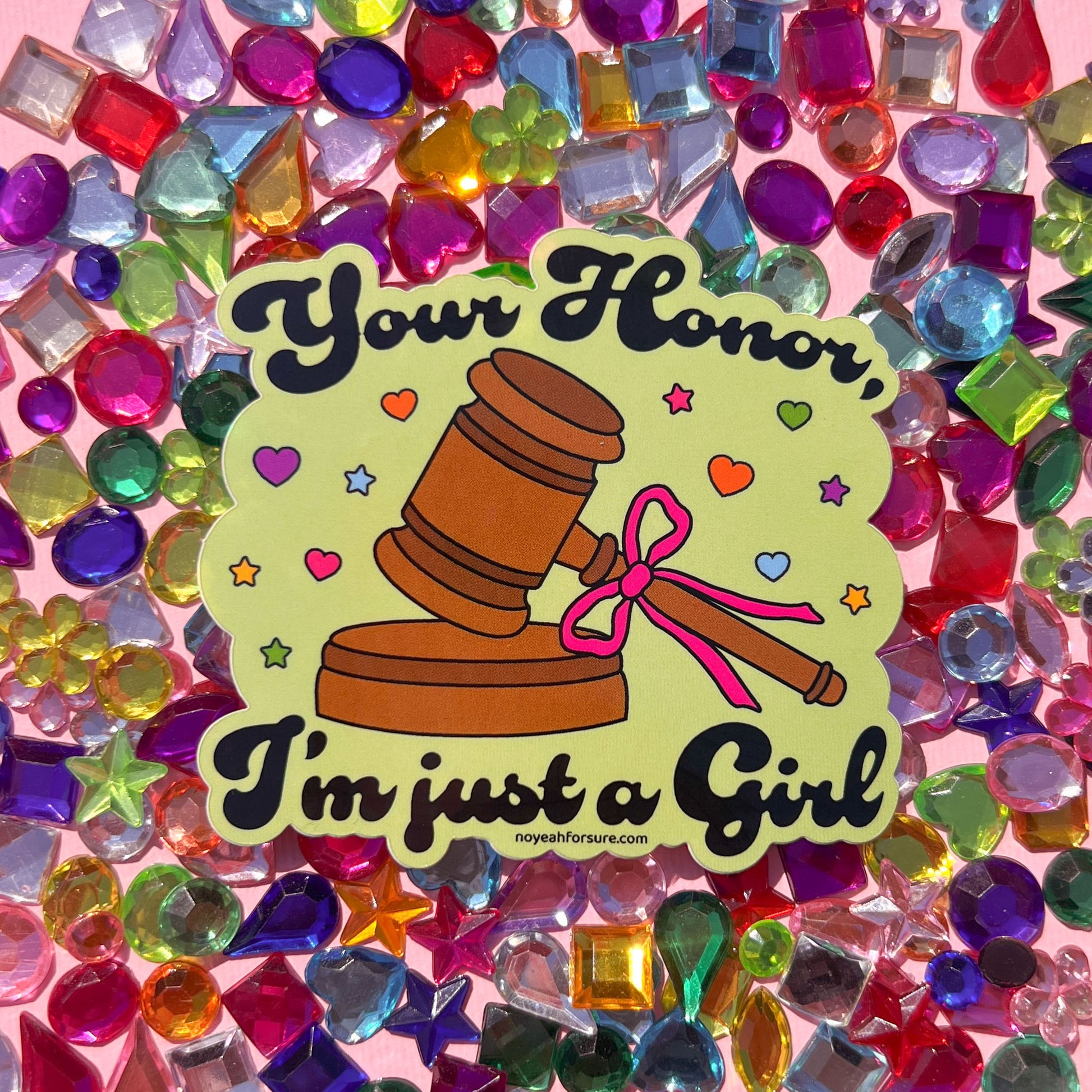 Sticker featuring a judge's gavel with a pink bow and the whimsical text, "your honor, i'm just a girl" surrounded by colorful hearts and stars on a colorful 
background with gems. 