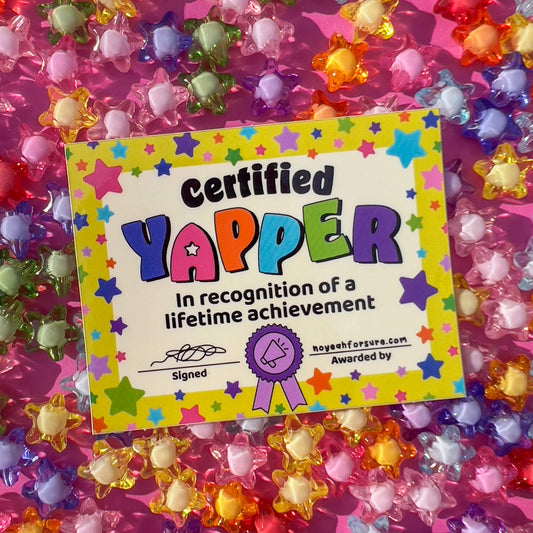Glossy vinyl sticker with a colorful 'Certified Yapper' design featuring stars, text, and a signature, resembling an award certificate.
